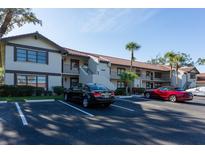 Inviting condo exterior with parking and mature landscaping for a serene residential appeal at 5630 Golf Pointe Dr # 206, Sarasota, FL 34243