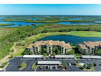 Beautiful aerial view of the community featuring a body of water, golf course, and covered parking at 7005 River Hammock Dr # 402, Bradenton, FL 34212