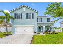 Two-story home showcasing a lush lawn, landscaping, a two-car garage, and decorative shutters at 7107 58Th E Ter, Palmetto, FL 34221
