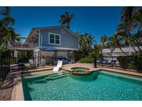 Gorgeous pool and patio with a hot tub, lounge chairs, and tropical ambiance at 750 Tarawitt Dr, Longboat Key, FL 34228