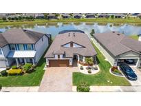 Beautiful waterfront single Gathering home with mature landscaping and neutral color palette at 7859 Yale Harbor Dr, Wesley Chapel, FL 33545