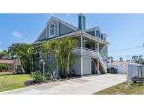 Inviting two-story home with a charming porch, lush landscaping, and a spacious driveway at 861 Nectar Rd, Venice, FL 34293