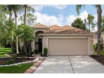 Charming single-Gathering home with a beige exterior, arched entrance, and well-maintained landscaping at 11274 Beebalm Cir, Lakewood Ranch, FL 34202