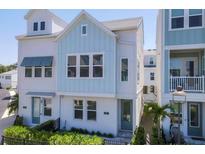 Charming two-story home featuring a blend of white and blue siding, complemented by lush greenery at 2340 Lindstrom St, Sarasota, FL 34237