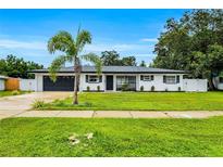Charming renovated single-story home with a well-manicured lawn and a palm tree in the front yard at 3856 Monica Pkwy, Sarasota, FL 34235