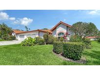 Well-manicured front yard with vibrant green grass and colorful landscaping adds curb appeal to this home at 4131 Salernes Ave # 3051, Sarasota, FL 34233