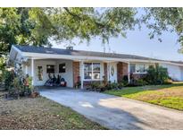 Charming single-story home featuring a brick facade, covered parking, and well-maintained landscaping at 4243 Maceachen Blvd, Sarasota, FL 34233