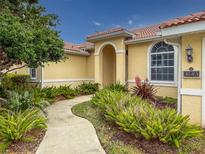 Charming home featuring a terracotta roof and a beautifully landscaped walkway leading to the inviting front entrance at 4613 Sweetmeadow Cir, Sarasota, FL 34238