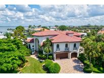 Stunning waterfront property with lush landscaping and a beautiful terracotta tile roof at 524 Schooner Ln, Longboat Key, FL 34228