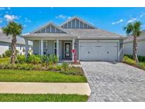 Charming single-story home featuring a two-car garage, well-manicured lawn, and tropical landscaping at 8107 Slipway Dr, Sarasota, FL 34240