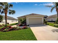 Charming single-story home with a neutral color palette, well-manicured lawn, and a paved driveway leading to the garage at 1618 White Breeze Cv, Bradenton, FL 34208