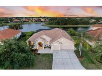 Waterfront home with tile roof, screened lanai and mature landscaping at sunset at 251 Dove Trl, Bradenton, FL 34212