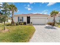 Charming single-story home featuring a paved driveway and a well-manicured lawn at 412 Daylily Blvd, Nokomis, FL 34275