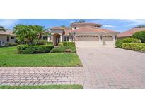 Charming two-story home with lush landscaping and a paver driveway leading to a three-car garage at 4668 Tuscana Dr, Sarasota, FL 34241
