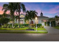 Beautiful single-story home with lush landscaping, mature palm trees, and charming architectural details at 4715 Spinnaker Dr, Bradenton, FL 34208