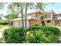 Charming townhome exterior featuring lush landscaping and a private two-car garage at 5230 Landings Blvd # 101, Sarasota, FL 34231