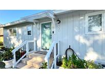 Charming home featuring a covered front porch, a stylish teal door, and well-maintained landscaping at 5231 32Nd E St, Bradenton, FL 34203