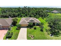 Beautiful single-story home featuring lush landscaping, a paver driveway, and an attached two-car garage at 5616 90Th Avenue E Cir, Parrish, FL 34219