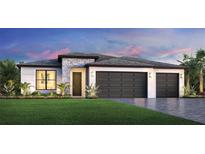 Contemporary single-story home with a three-car garage, stone accents, and manicured lawn at 5784 Freestone Cir, Apollo Beach, FL 33572
