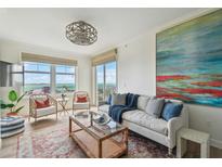 Comfortable living area with scenic water view windows, casual seating and contemporary decor at 750 N Tamiami Trl # 1203, Sarasota, FL 34236