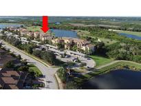 Beautiful aerial view of condo community with lakes, mature trees, and covered parking at 7803 Grand Estuary Trl # 205, Bradenton, FL 34212