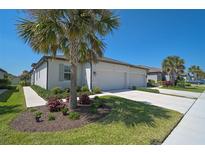 Beautiful home featuring a three-car garage, well-manicured lawn, and lush landscaping at 8553 Whispering St, Sarasota, FL 34240