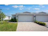 Charming home featuring a two-car garage, beautiful brick driveway, and manicured landscaping at 16114 Ivy Ridge Ct, Port Charlotte, FL 33953