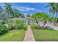 Charming home featuring a brick walkway, lush landscaping, and a welcoming blue front door at 1960 Lincoln Dr, Sarasota, FL 34236