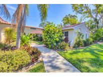 Beautiful front exterior of home with mature landscaping and red tile roof at 2267 Pueblo Ln # V40, Sarasota, FL 34231