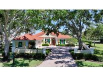 Charming one story home with brick driveway, lush green yard, and mature trees at 228 Saint James Park, Osprey, FL 34229