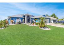 Charming single-story home featuring a well-manicured lawn and decorative landscaping at 23088 Allen Ave, Port Charlotte, FL 33980