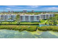 Beautiful aerial view of beach condos, manicured lawns, and water views on a bright, sunny day at 2450 Harbourside Dr # 233, Longboat Key, FL 34228
