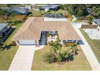A captivating aerial view of a single-story home with a beautiful lawn, screened pool, and a cozy front patio at 259 Hammock Ter, Venice, FL 34293