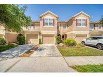 Inviting townhouse with attached garages, neutral stucco, red shutters and well-maintained landscaping at 2819 Conch Hollow Dr, Brandon, FL 33511
