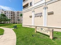 Exterior view of Whittier Manor building with guest parking sign surrounded by lush green lawn and landscaping at 3730 Cadbury Cir # 631, Venice, FL 34293