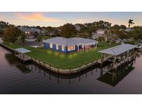 Waterfront home boasts a metal roof, lush landscaping, and a private dock with boat lift at 4517 Pinfish Ln, Palmetto, FL 34221