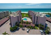 Coastal condo complex featuring a pool, lush landscaping and direct beach access at 6480 Midnight Pass Rd # 316, Sarasota, FL 34242