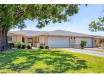 Charming condo with an attached two-car garage, manicured lawn, and mature shade trees at 7069 W Country Club N Dr # 7069, Sarasota, FL 34243