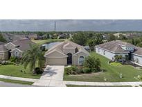 Inviting single-story home with a well-manicured lawn, complemented by lush landscaping and a tranquil pond view at 11319 82Nd E St, Parrish, FL 34219