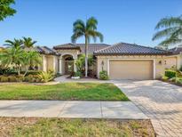 Charming single-story home with well-manicured lawn, lush landscaping and a neutral color scheme at 13644 Brilliante Dr, Venice, FL 34293