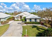 Attractive single-Gathering home boasts a tile roof, large driveway, and neatly manicured lawn in a bright setting at 22324 Wexford Blvd, Venice, FL 34293