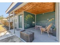 Charming front porch features a seating area, wood ceiling, and decorative garden art at 2350 Novus St, Sarasota, FL 34237
