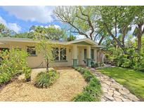 Charming single-story home featuring a stone pathway, lush landscaping, and a welcoming entrance at 3004 Bay Shore Cir, Sarasota, FL 34234