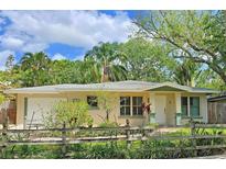 Charming home featuring a well-manicured lawn, lush landscaping, and a rustic wooden fence at 3004 Bay Shore Cir, Sarasota, FL 34234
