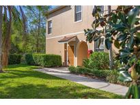 Charming two-story tan home with a well-manicured lawn, lush landscaping, and a welcoming covered entryway at 3671 Parkridge Cir # 8-201, Sarasota, FL 34243