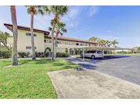 Condo exterior with well-maintained landscaping, covered parking, and mature palm trees on a sunny day at 3690 Pinecrest St # 124, Sarasota, FL 34232