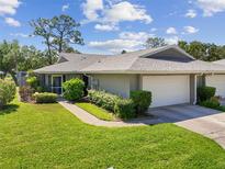 Well-maintained home with a charming gray exterior, attached garage, and manicured landscaping at 3921 Center Gate Cir # 11, Sarasota, FL 34233