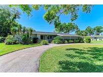 Charming single-story home featuring a well-manicured lawn and a circular driveway at 4611 17Th W Ave, Bradenton, FL 34209