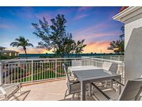 Relaxing balcony view featuring white patio furniture, tropical landscaping, and serene ocean backdrop at 5055 Gulf Of Mexico Dr # 232, Longboat Key, FL 34228