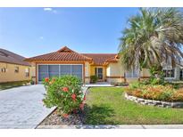 Charming home with a terracotta tile roof, vibrant landscaping, and a spacious driveway at 6415 39Th W Ave, Bradenton, FL 34209